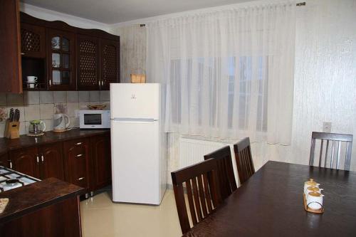 ラーゼシュチュナにあるCottage "Pyate Koleso"のキッチン(冷蔵庫、テーブル、椅子付)