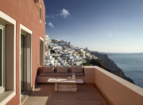 a balcony with a couch and a view of a city at Villa Bordeaux in Fira