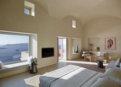 a bedroom with a large bed and a large window at Villa Bordeaux in Fira