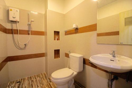 a bathroom with a toilet and a sink at Green Apple Villa in Sattahip