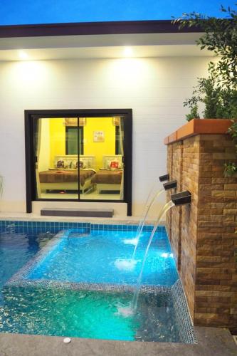 a swimming pool with a water fountain at Baan Big Family Pool Villa in Hua Hin