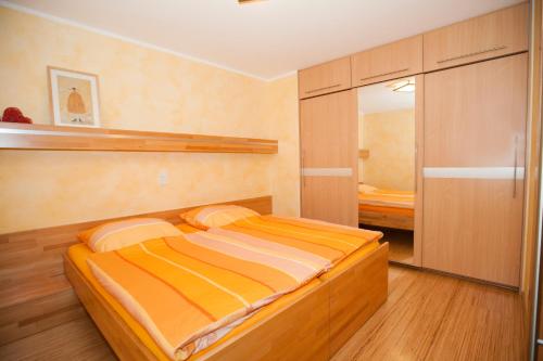 a small bedroom with a bed and a mirror at Landhaus Hof-Schlenstedt in Stadtallendorf