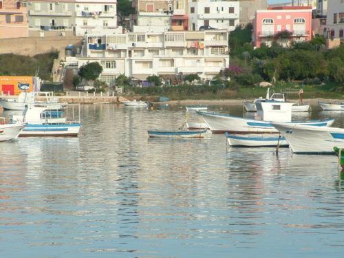 a group of boats in a body of water with buildings at La Salina in Lampedusa
