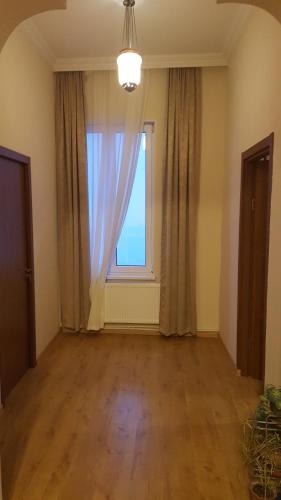 an empty room with a large window and wooden floors at Apartment Chavchavadze 5 in Sighnaghi