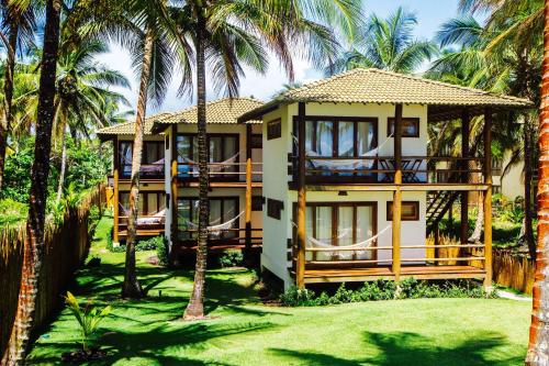 a house with palm trees in front of it at Dreamland Bungalows - Taipú de Fora - Barra Grande in Barra Grande