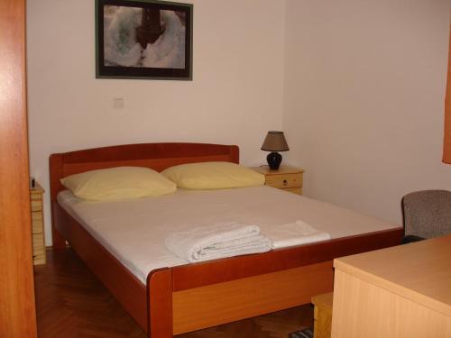 a small bedroom with a bed with a wooden frame at Brko Apartment in Medulin