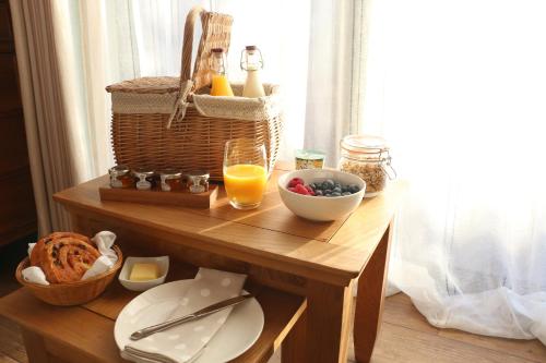 una mesa con una cesta de comida y un vaso de zumo de naranja en The Old Potting Shed en York