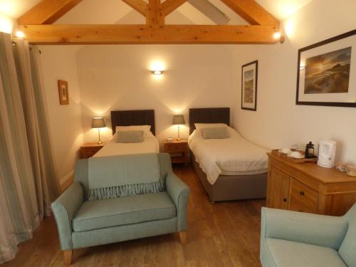 um quarto com 2 camas, um sofá e uma cadeira em The Old Potting Shed em York