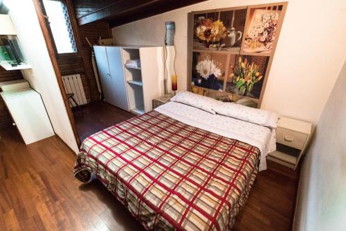 ein kleines Schlafzimmer mit einem Bett und einem Kühlschrank in der Unterkunft Mono Verde in Turin