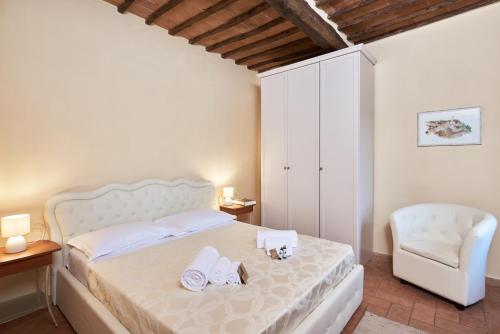 シエナにあるAppartamento Palazzettoのベッドルーム1室(ベッド1台、椅子、タオル付)