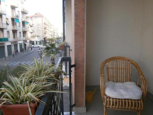 a wicker chair sitting on a balcony with plants at Hotel Milanesina in Alassio