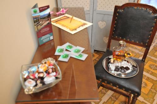 a table with a plate of candy and a cake on it at B&b Le Cycas in Castellammare di Stabia
