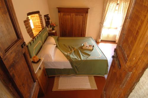 a small bedroom with a bed with a green canopy at Castello Di Gargonza in Monte San Savino