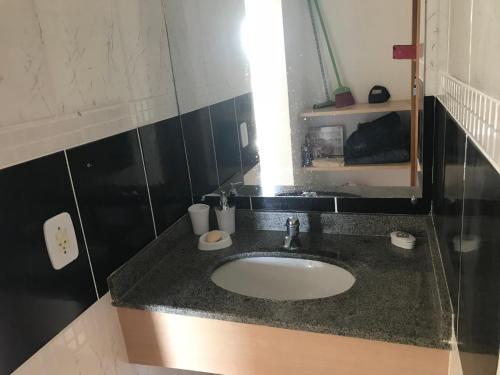 W łazience znajduje się umywalka i lustro. w obiekcie Pontal do Lago Flat w mieście Caldas Novas