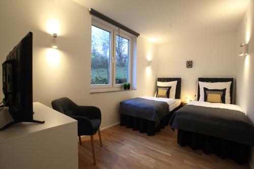 a room with two beds and a tv and a window at 1Step2AllCities House&Garden in Wuppertal