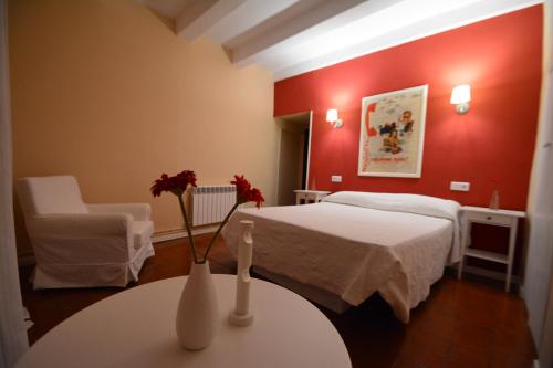 a bedroom with a bed and a table with flowers on it at Casa Rural La Plaza in Valoria la Buena