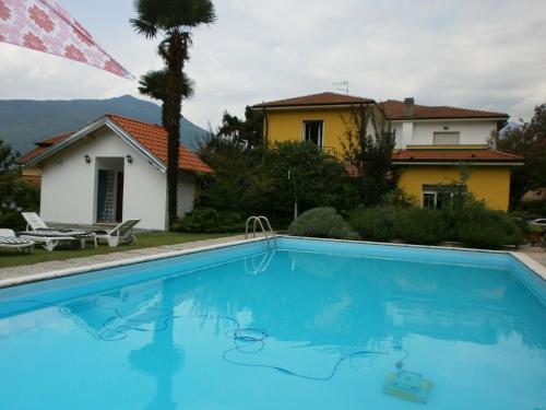 a swimming pool in front of a house at Albergo Paradiso in Maccagno con Pino e Veddasca