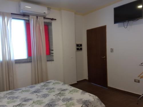 1 dormitorio con cama, ventana y TV en Hotel Residencial España en Salta