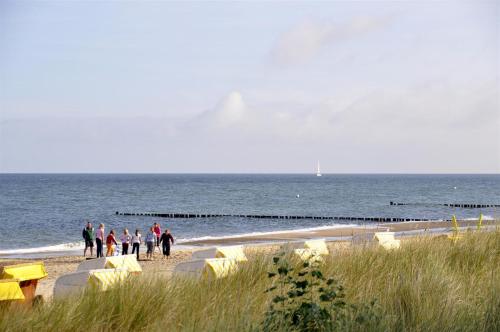 a group of people walking on the beach at Am Weststrand Aparthotel Kühlungsborn in Kühlungsborn