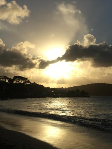 a sunset on the beach with the sun setting at Le Désircaraïbe in Tartane
