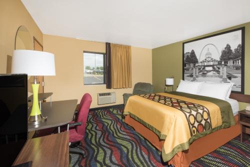 a hotel room with a bed and a desk at Super 8 by Wyndham Farmington in Farmington