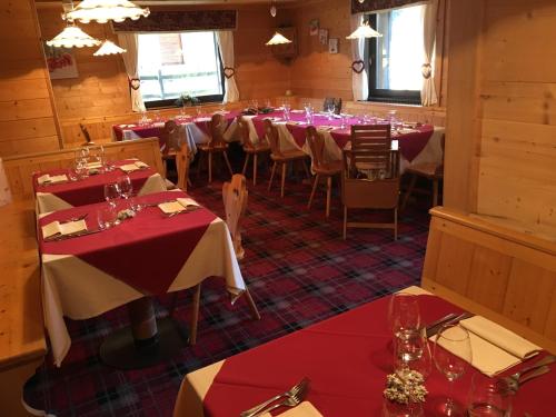 a dining room with red and white tables and chairs at Hotel Gran Baita in Gressoney-Saint-Jean