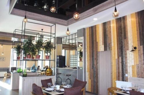 a restaurant with tables and chairs and a kitchen at Bakuriani Residence 87 in Bakuriani
