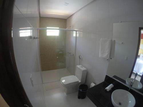 a bathroom with a shower and a toilet and a sink at Pousada Pedra Grande in Morros