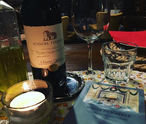 a bottle of wine sitting on a table with a glass at Podere Terreno alla via della volpaia in Radda in Chianti