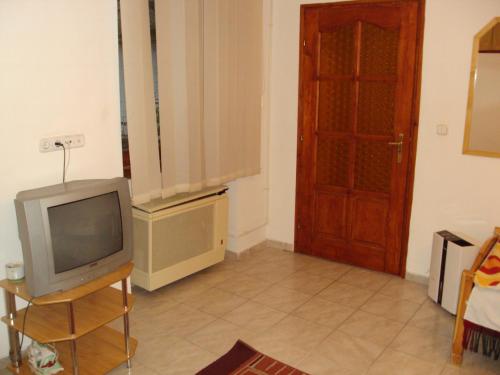a living room with a tv and a door at Erik Apartments in Budapest