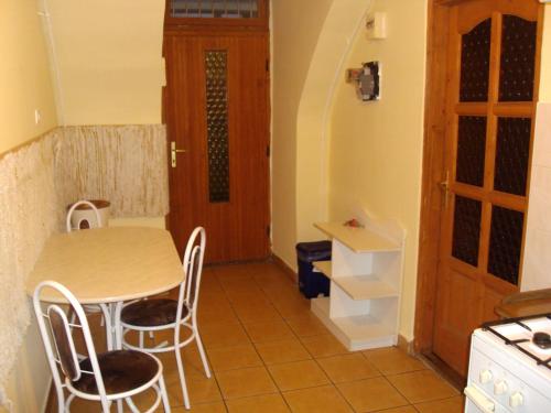 - une cuisine avec une table, des chaises et une porte dans l'établissement Erik Apartments, à Budapest
