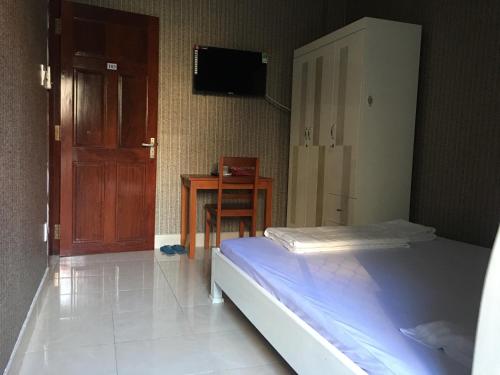 a bedroom with a bed and a table and a television at Thu Đô Motel in Vung Tau