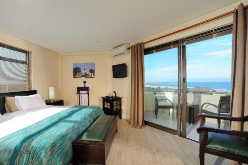 a bedroom with a bed and a view of the ocean at Beach Hotel Swakopmund in Swakopmund