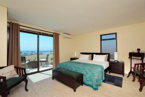 a bedroom with a bed and a large window at Beach Hotel Swakopmund in Swakopmund