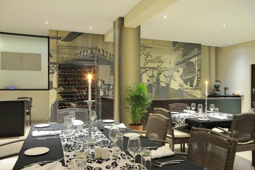 a dining room with tables and chairs and a wine cellar at Beach Hotel Swakopmund in Swakopmund
