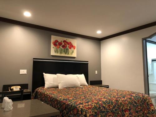 a bedroom with a bed and a painting on the wall at Starlight Inn South El Monte in South El Monte