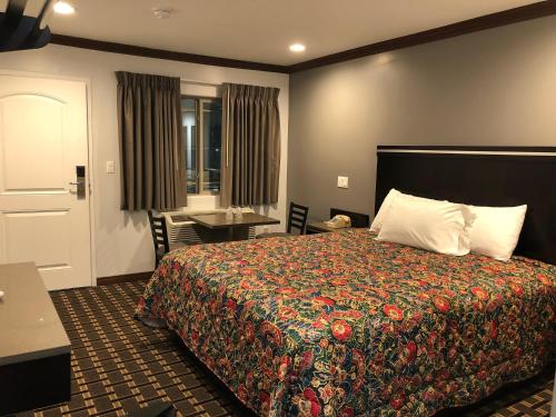 a hotel room with a bed and a desk at Starlight Inn South El Monte in South El Monte