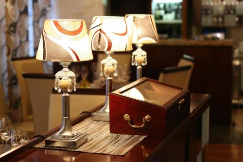 a table with two lamps and a box on it at Hotel Waldinger in Osijek