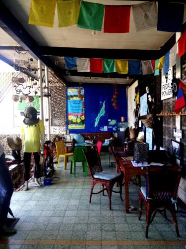 a person walking in a room with tables and chairs at Bugoy Bikers Hostel in Cebu City