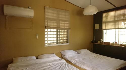 two beds in a room with two windows at 自然海naturalhigh in Dahan