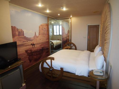 a hotel room with a bed and a television at Day Chen Hotel in Yilan City