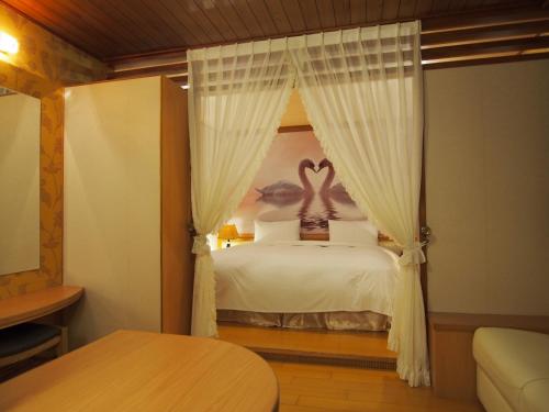 a bedroom with a bed with two swans on it at Day Chen Hotel in Yilan City