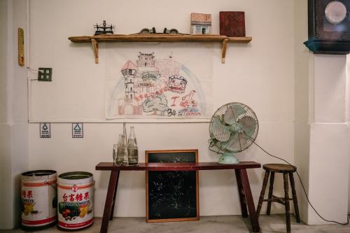 a room with a table and a fan on a wall at 84 In Tainan in Tainan