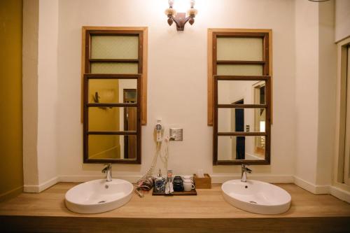 two sinks in a bathroom with two mirrors at 84 In Tainan in Tainan