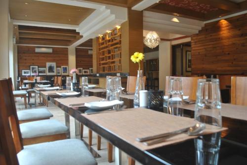 Gakyil Thimphu في تيمفو: غرفة طعام مع طاولات وكراسي في مطعم