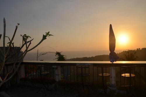 a bird sitting on a table with the sunset in the background at Rara Villas Lombok in Senggigi 