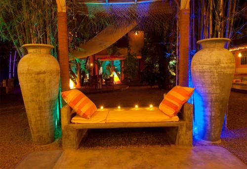 two large vases sitting next to a bench with lights at Dickman Resort "The Boutique Hotel" in Negombo