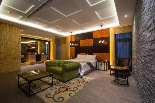 a hotel room with a bed and a couch at U-Her Hotel in Taichung