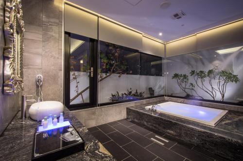 a bathroom with a tub and a large window at U-Her Hotel in Taichung