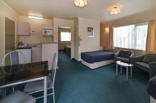 a hotel room with a bed and a kitchen at Geneva Motor Lodge in Rotorua